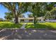 Beautiful home with a manicured lawn and mature trees lining the walkway and the property at 4391 Ne Cherry Ne St, St Petersburg, FL 33703
