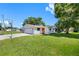 Charming single-story home features an attached garage, lush lawn, and a basketball hoop for outdoor fun at 4391 Ne Cherry Ne St, St Petersburg, FL 33703