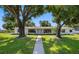 Inviting home with a walkway, surrounded by mature trees and a well-kept lawn at 4391 Ne Cherry Ne St, St Petersburg, FL 33703