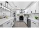 Kitchen boasts stainless steel appliances, white cabinetry, and stunning countertops with a stylish backsplash at 4391 Ne Cherry Ne St, St Petersburg, FL 33703