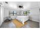 Spacious main bedroom with a ceiling fan, light gray walls, two windows and lots of natural light at 4391 Ne Cherry Ne St, St Petersburg, FL 33703