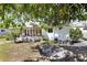 Spacious backyard view with a patio, bordered by mature trees and a well-maintained lawn at 525 Skylark Nw Ln, Port Charlotte, FL 33952