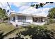 The backyard has a covered patio area, grass and some scattered trees and bushes at 525 Skylark Nw Ln, Port Charlotte, FL 33952