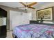 Comfortable bedroom featuring tiled floors, ceiling fan and a closet with bi-fold doors at 525 Skylark Nw Ln, Port Charlotte, FL 33952