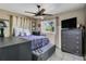 Cozy bedroom with natural light from a window, ceiling fan, and tiled floor at 525 Skylark Nw Ln, Port Charlotte, FL 33952