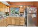 Functional kitchen with wood cabinetry, stainless steel refrigerator, and tile backsplash at 525 Skylark Nw Ln, Port Charlotte, FL 33952