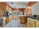 Functional kitchen featuring wood cabinetry, tile flooring, and ample countertop space at 525 Skylark Nw Ln, Port Charlotte, FL 33952