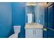 Powder room with blue walls, modern vanity and brushed gold hardware at 5253 Boardwalk St, Holiday, FL 34690