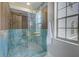 Modern shower with glass door, and blue and wood style tile at 5253 Boardwalk St, Holiday, FL 34690