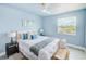 Bright bedroom with ceiling fan, white linens and coastal accents and artwork at 5253 Boardwalk St, Holiday, FL 34690