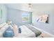 Bright bedroom with ceiling fan, white linens and coastal accents and artwork at 5253 Boardwalk St, Holiday, FL 34690