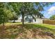 Expansive backyard with mature trees and a screened-in patio, ideal for outdoor entertaining at 5390 Greystone Dr, Spring Hill, FL 34609