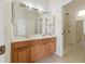 Bathroom featuring a double vanity, large mirror, and a walk-in shower with glass door at 5390 Greystone Dr, Spring Hill, FL 34609
