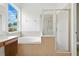 Bright bathroom with a glass shower, garden tub, and a large window providing plenty of natural light at 5390 Greystone Dr, Spring Hill, FL 34609