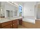 Bright bathroom features a glass shower, garden tub, and a double sink vanity for convenience at 5390 Greystone Dr, Spring Hill, FL 34609