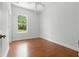 Cozy bedroom with hardwood floors, ceiling fan, neutral walls, and a bright window view at 5390 Greystone Dr, Spring Hill, FL 34609