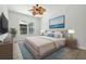Bright bedroom features a king-size bed, ceiling fan, and an art piece above the bed at 5390 Greystone Dr, Spring Hill, FL 34609