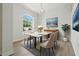Dining room with modern table, four chairs, chandelier and a large window allowing for an abundance of natural light at 5390 Greystone Dr, Spring Hill, FL 34609
