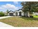 Charming one-story home boasts a well-manicured lawn, two-car garage, and classic stucco exterior with black trim at 5390 Greystone Dr, Spring Hill, FL 34609