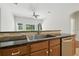 Kitchen sink with stainless steel appliances and granite countertop under a decorative ceiling fan at 5390 Greystone Dr, Spring Hill, FL 34609