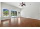 Bright living room featuring hardwood floors, a ceiling fan, and sliding glass doors to the backyard at 5390 Greystone Dr, Spring Hill, FL 34609