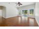 Spacious living room with hardwood floors, ceiling fan, high ceilings, and sliding door to outside at 5390 Greystone Dr, Spring Hill, FL 34609