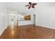Open-concept living room with hardwood floors and ceiling fan, flowing into kitchen and dining area at 5390 Greystone Dr, Spring Hill, FL 34609
