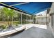 Screened patio with blue awning and custom planters offers an inviting space to enjoy nature at 5390 Greystone Dr, Spring Hill, FL 34609