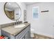 Updated bathroom with granite countertop, silver faucet and hardware, and a round mirror at 5401 7Th N Ave, St Petersburg, FL 33710