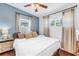 Well-lit bedroom featuring light blue accent wall, two windows, and hardwood floors at 5401 7Th N Ave, St Petersburg, FL 33710