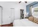 A clean bedroom with blue accent wall, two windows, and ceiling fan at 5401 7Th N Ave, St Petersburg, FL 33710