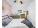 Bright bedroom with pink accent wall, ceiling fan, and gray bedding at 5401 7Th N Ave, St Petersburg, FL 33710