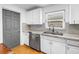 Well-lit kitchen with stainless steel appliances, white cabinetry, and mosaic backsplash at 5401 7Th N Ave, St Petersburg, FL 33710