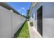 Side yard with lush grass, privacy fence and walkway leading to back entry at 5401 7Th N Ave, St Petersburg, FL 33710