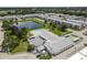 An aerial view of the condo building, pond, tennis court, and surrounding community at 6000 20Th N St # 123, St Petersburg, FL 33714