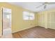 Bedroom with a view to the bathroom features wood floors, a closet, and a ceiling fan at 6000 20Th N St # 123, St Petersburg, FL 33714