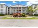 Exterior of condo featuring manicured landscaping and circle driveway with the American flag at 6000 20Th N St # 123, St Petersburg, FL 33714