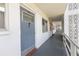 Exterior hallway featuring unit door, brick trim, white walls, and access to the outside at 6000 20Th N St # 123, St Petersburg, FL 33714