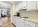 The kitchen shows white cabinets, countertops and appliances, plus view into the living room at 6000 20Th N St # 123, St Petersburg, FL 33714