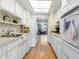 This kitchen boasts bright white cabinets and wood-look flooring, with an open view to the living room at 6000 20Th N St # 123, St Petersburg, FL 33714