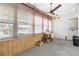 Bright living room with large windows, ceiling fan, and wood paneling accents at 6000 20Th N St # 123, St Petersburg, FL 33714