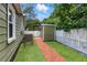 Charming backyard area featuring a brick path, shed, and privacy fence, perfect for relaxing or gardening at 6301 Hobson Ne St, St Petersburg, FL 33702