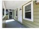 Inviting front porch featuring a white front door, neutral siding, and an adjacent screened porch at 6301 Hobson Ne St, St Petersburg, FL 33702