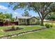 Charming single story home showcasing a well-manicured lawn, landscaping, and mature trees at 6301 Hobson Ne St, St Petersburg, FL 33702