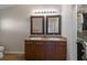 Bathroom with double sink vanity, framed mirrors, and wood floors at 7001 Interbay Blvd # 219, Tampa, FL 33616