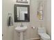 Charming half bathroom with pedestal sink, framed mirror, and neutral decor at 7001 Interbay Blvd # 219, Tampa, FL 33616