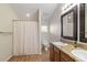 Well-lit bathroom featuring wood cabinets, granite countertops, a double sink, and a shower at 7001 Interbay Blvd # 219, Tampa, FL 33616