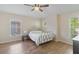 Bright bedroom featuring a metal bed frame, wood floors, and three large windows at 7001 Interbay Blvd # 219, Tampa, FL 33616