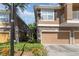 Inviting condo building with tan exterior, stone accents, brown garage doors, and lush landscaping at 7001 Interbay Blvd # 219, Tampa, FL 33616