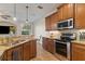 Well-lit kitchen featuring granite countertops, stainless steel appliances, and wood cabinetry at 7001 Interbay Blvd # 219, Tampa, FL 33616